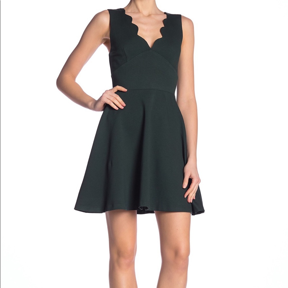 Black sleeveless mini dress w/ scalloped neckline.